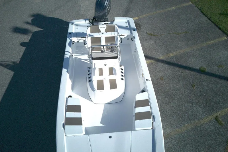 Slide: The Image of 2026 Frontier 2104 boat, aerial view, white with striped seating, parked on asphalt. - 4