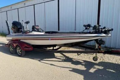 The Image of 2012 Skeeter FX20 bass boat on trailer, parked outdoors near storage units. - 0