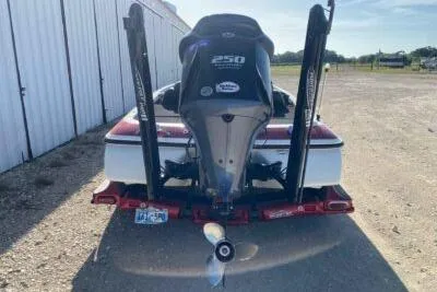 Slide: The Image of 2012 Skeeter FX20 boat with 250 HP engine, parked outdoors near a storage facility. - 1