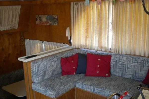 Slide: The Image of 1996 Gibson 41 Classic Houseboat interior with cozy seating, red cushions, and wood paneling. - 15
