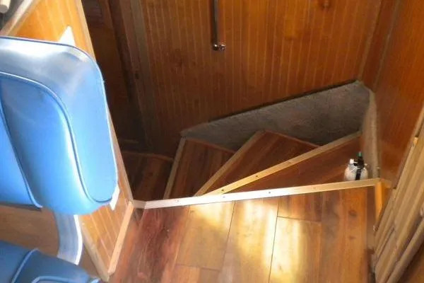 Slide: The Image of Staircase inside 1996 Gibson 41 Classic Houseboat with wooden paneling and blue seating. - 17