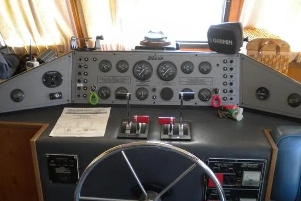 Slide: The Image of Control panel of a 1996 Gibson 41 Classic Houseboat with steering wheel and gauges. - 19