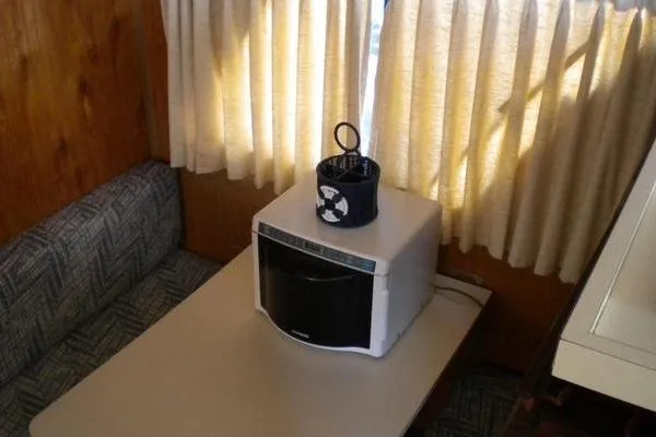 Slide: The Image of Interior of 1996 Gibson 41 Classic Houseboat with microwave and curtains. - 20