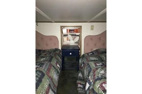 Slide: The Image of 1996 Gibson 41 Classic Houseboat bedroom with twin beds and a central nightstand. - 22