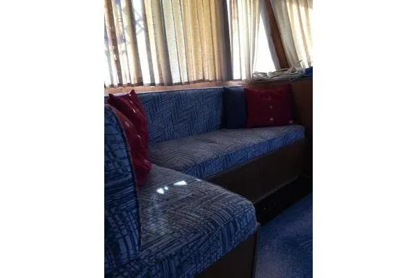 Slide: The Image of Interior of 1996 Gibson 41 Classic Houseboat with blue patterned seating and red cushions. - 25