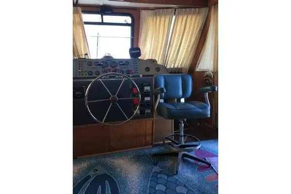 Slide: The Image of 1996 Gibson 41 Classic Houseboat helm with steering wheel and captain's chair. - 27