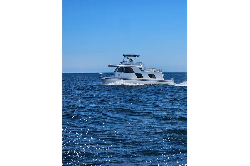 Slide: The Image of 1994 Gibson 41 Classic Houseboat cruising on open blue waters under clear skies. - 28