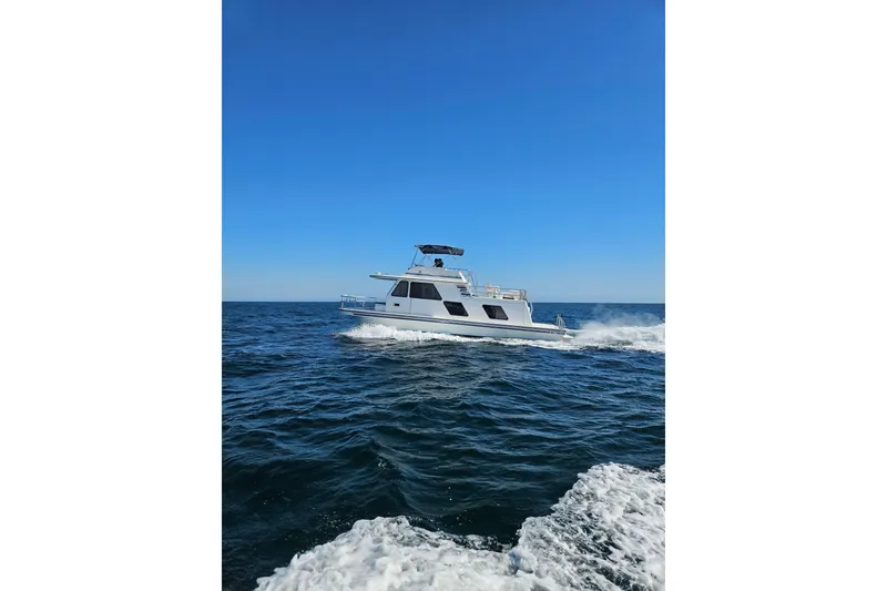 Slide: The Image of 1994 Gibson 41 Classic Houseboat cruising on open water under clear blue sky. - 29