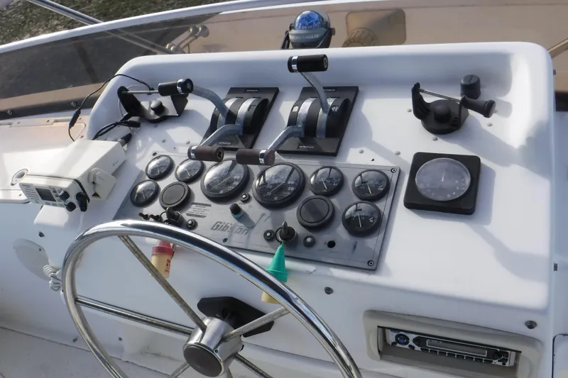 Slide: The Image of Control panel of a 1994 Gibson 41 Classic Houseboat with steering wheel and gauges. - 45