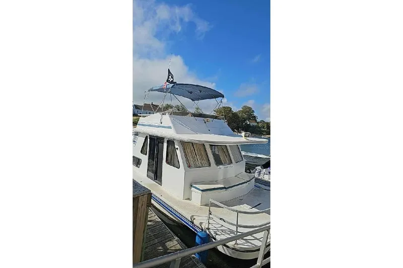 Slide: The Image of 1996 Gibson 41 Classic Houseboat docked under a clear blue sky. - 5
