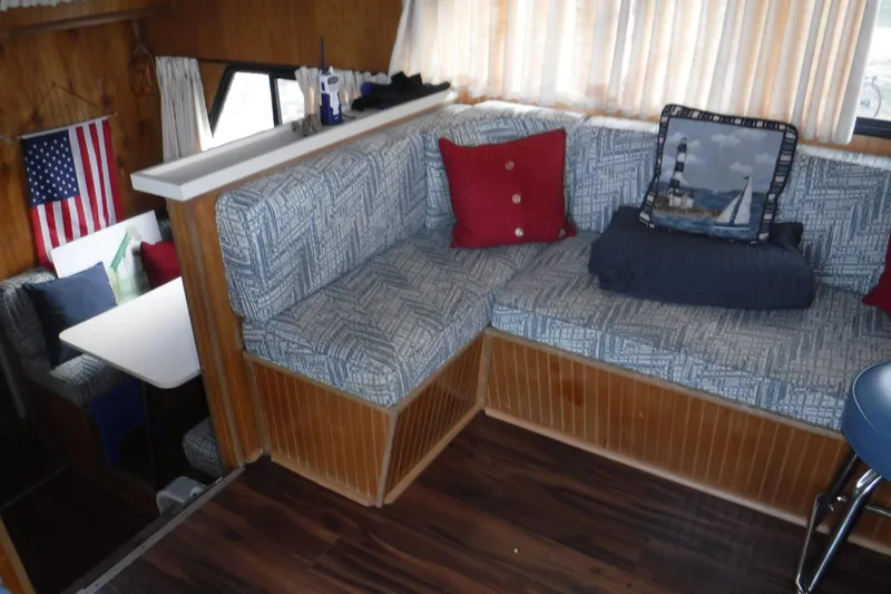 Slide: The Image of 1994 Gibson 41 Classic Houseboat interior with cozy seating, nautical decor, and American flag. - 56
