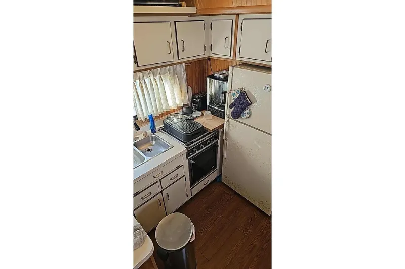 Slide: The Image of Compact kitchen in a 1996 Gibson 41 Classic Houseboat with stove, fridge, and cabinets. - 7