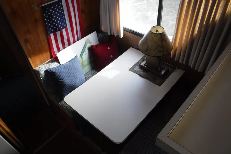 Slide: The Image of 1994 Gibson 41 Classic Houseboat interior with table, lamp, and American flag decor. - 70