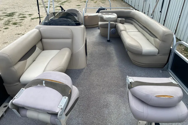 Slide: The Image of 2015 Sun Tracker Fishin' Barge 20 DLX interior with beige seating and fishing chairs. - 6