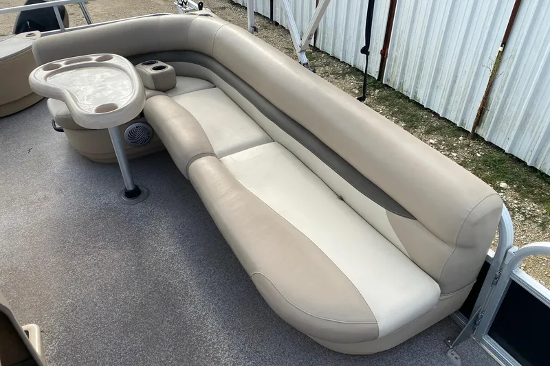 Slide: The Image of 2015 Sun Tracker Fishin' Barge 20 DLX interior with beige seating and table. - 9