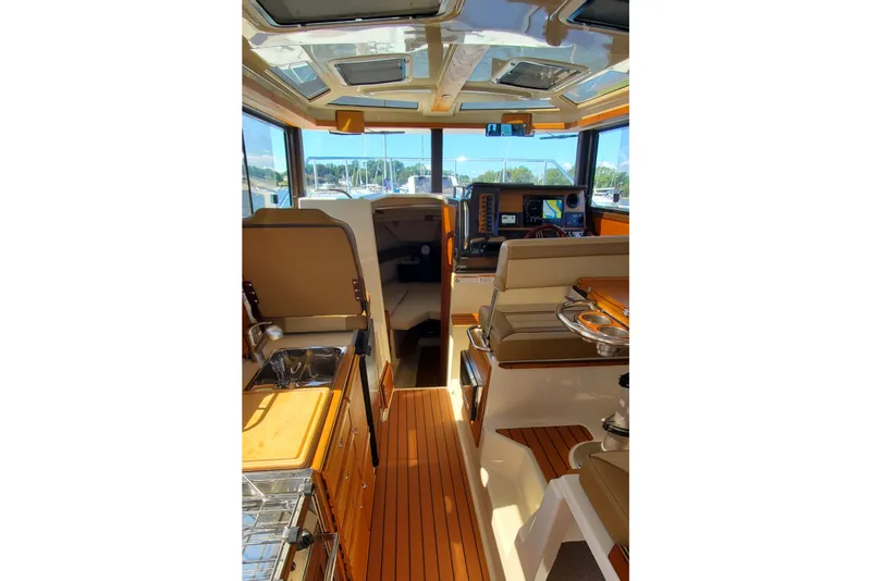 Slide: The Image of 2024 Ranger Tugs R-27 interior with modern helm, seating, and wood finishes. - 11