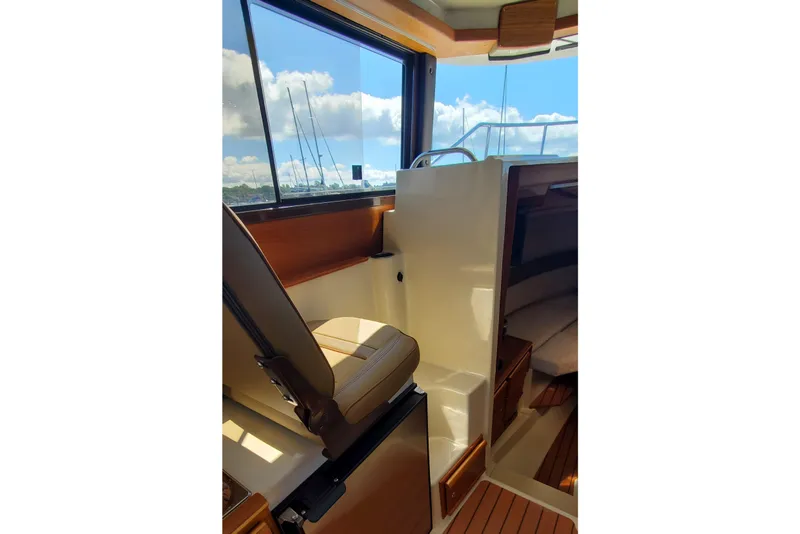 Slide: The Image of 2024 Ranger Tugs R-27 interior with helm seat and cabin view. - 18