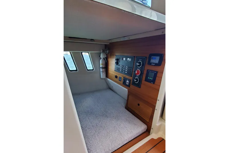 Slide: The Image of 2024 Ranger Tugs R-27 cabin interior with control panel and fire extinguisher. - 22