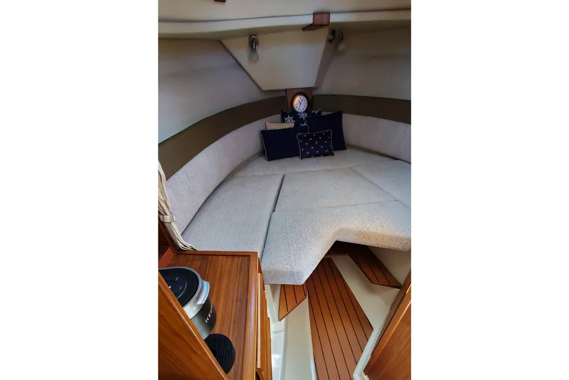 Slide: The Image of 2024 Ranger Tugs R-27 cabin interior with cozy seating and nautical decor. - 23