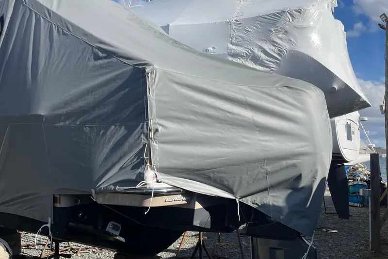 Slide: The Image of 2024 Ranger Tugs R-27 boat covered in protective tarp at a marina. - 29