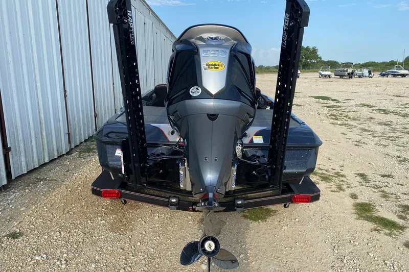 Slide: The Image of 2026 Skeeter ZXE21 boat with powerful outboard motor, parked on gravel near storage facility. - 4