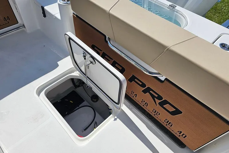 Slide: The Image of 2025 Sea Pro 242 Center Console boat with open storage compartment and cushioned seating. - 13