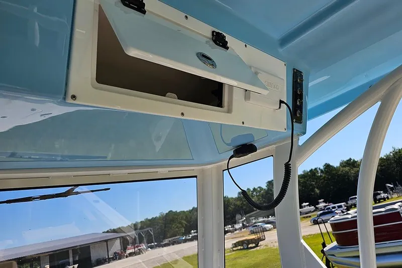 Slide: The Image of 2025 Sea Pro 242 Center Console boat interior with open storage compartment and control panel. - 24