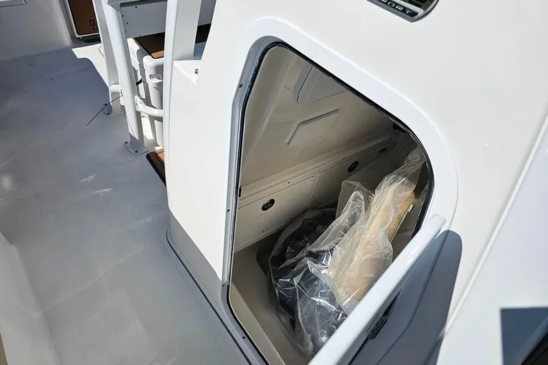 Slide: The Image of 2025 Sea Pro 242 Center Console boat storage compartment with seating and equipment. - 26