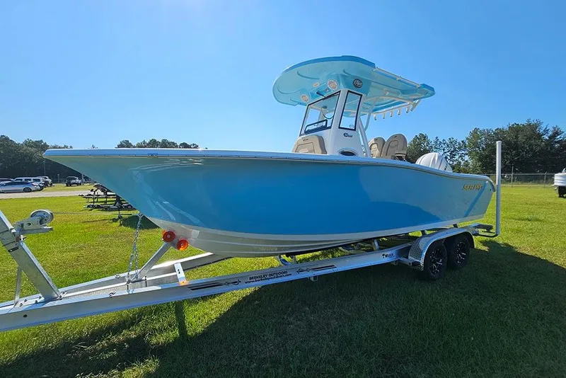 Slide: The Image of 2025 Sea Pro 242 Center Console boat on trailer, displayed outdoors under clear blue sky. - 6