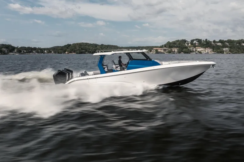 The Image of 2026 Fountain 43 SCX speedboat cruising on a lake with scenic shoreline background. - 1