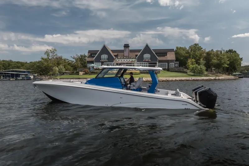 Slide: The Image of 2026 Fountain 43 SCX boat cruising on a lake near a large house. - 3