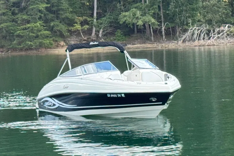 Slide: The Image of 2005 Rinker 232 Captiva Bowrider on calm lake with forested background. - 11