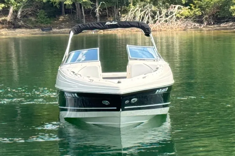 Slide: The Image of 2005 Rinker 232 Captiva Bowrider on calm lake with forested background. - 13