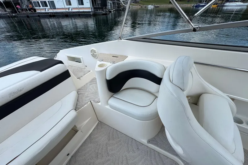 Slide: The Image of 2005 Rinker 232 Captiva Bowrider interior with white seating and lake view. - 21