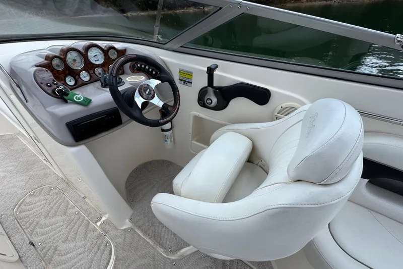 Slide: The Image of 2005 Rinker 232 Captiva Bowrider cockpit with steering wheel and gauges. - 23