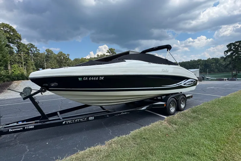Slide: The Image of 2005 Rinker 232 Captiva Bowrider on trailer, parked outdoors under cloudy sky. - 26