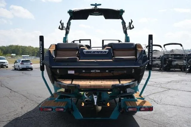 Slide: The Image of 2026 Supra SL boat, rear view, parked on asphalt, showcasing sleek design and features. - 4