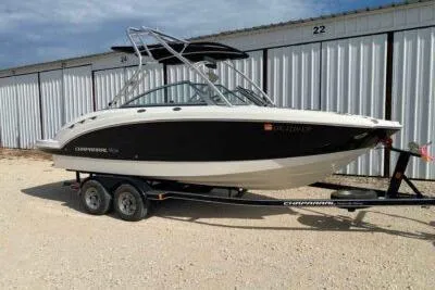The Image of 2008 Chaparral Sunesta 224 boat on trailer, parked near storage units. - 1