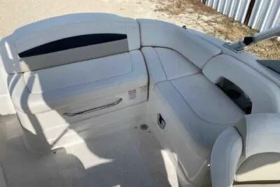 Slide: The Image of 2008 Chaparral Sunesta 224 boat interior with white seating and storage compartments. - 10