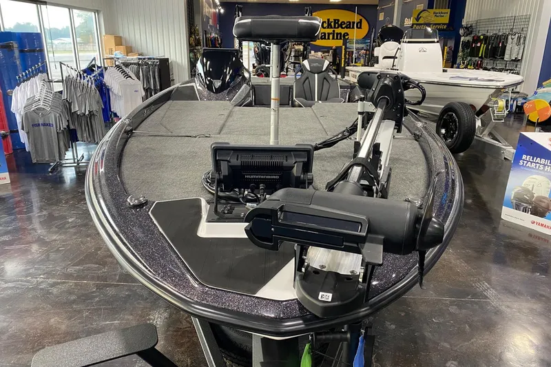 Slide: The Image of 2026 Skeeter ZXE21 boat displayed in showroom with fishing equipment. - 2