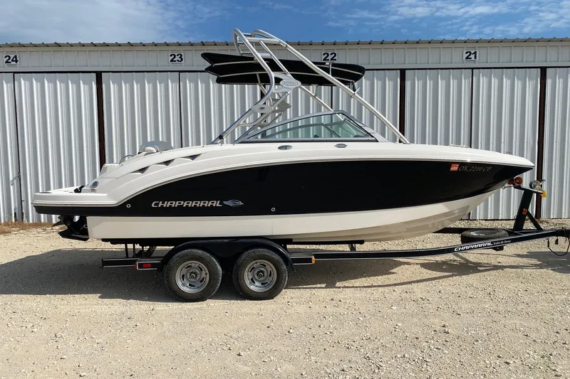The Image of 2008 Chaparral Sunesta 224 boat on trailer, parked outdoors near storage units. - 0