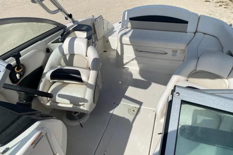 Slide: The Image of 2008 Chaparral Sunesta 224 boat interior with white seating and steering wheel. - 11