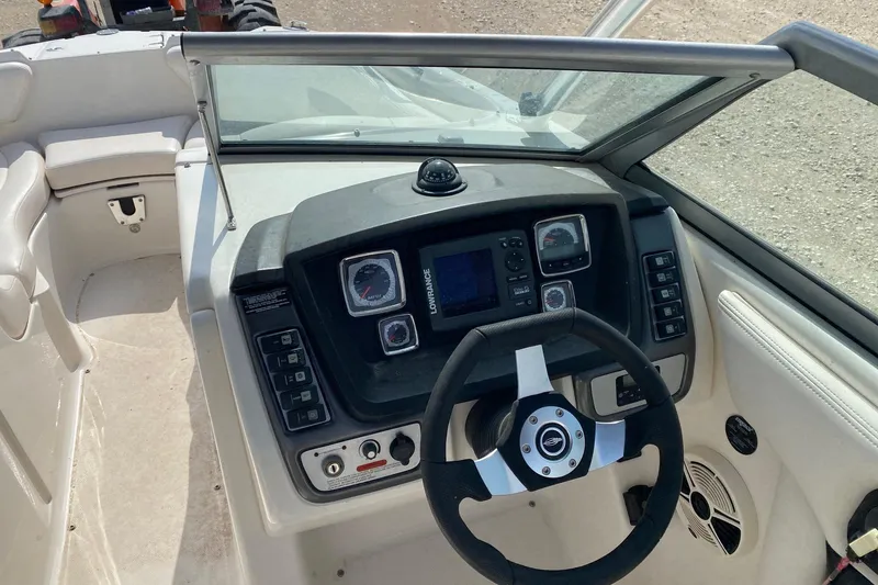 Slide: The Image of 2008 Chaparral Sunesta 224 boat dashboard with steering wheel and control panel. - 6