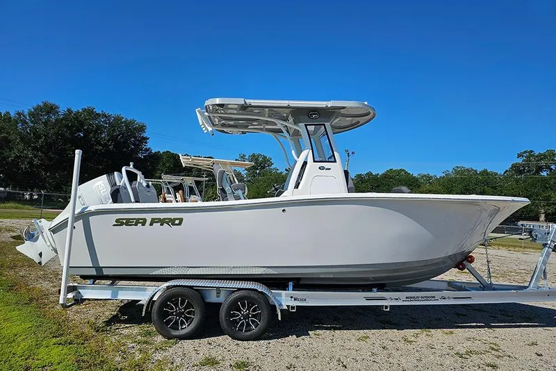 The Image of 2026 Sea Pro 245 Sandbar boat on trailer, parked outdoors under clear blue sky. - 1