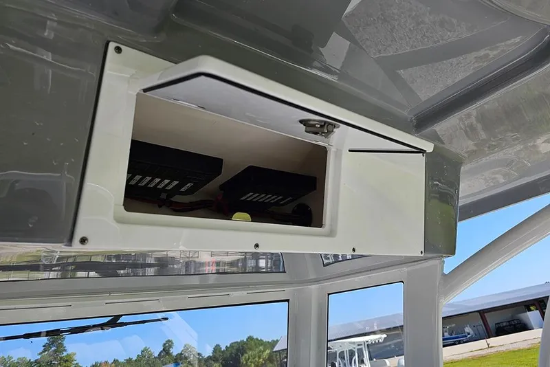 Slide: The Image of Open storage compartment on 2026 Sea Pro 245 Sandbar boat, showcasing interior electronics. - 29