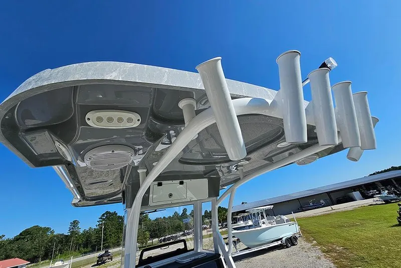 Slide: The Image of 2026 Sea Pro 245 Sandbar boat with rod holders and canopy under clear blue sky. - 31