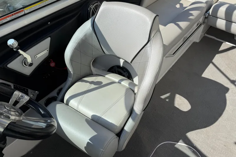 Slide: The Image of 2015 MasterCraft X30 boat interior with gray captain's seat and steering wheel. - 13