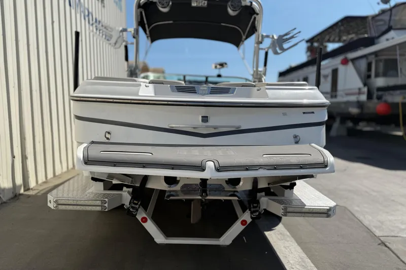Slide: The Image of 2015 MasterCraft X30 boat rear view in a marina setting. - 4