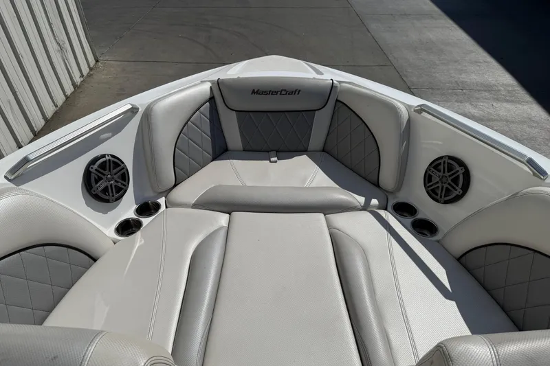 Slide: The Image of 2015 MasterCraft X30 boat interior with cushioned seating and built-in speakers. - 6