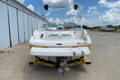 Slide: The Image of 2004 Chaparral 230 SSi boat, rear view, parked outdoors under a blue sky. - 5